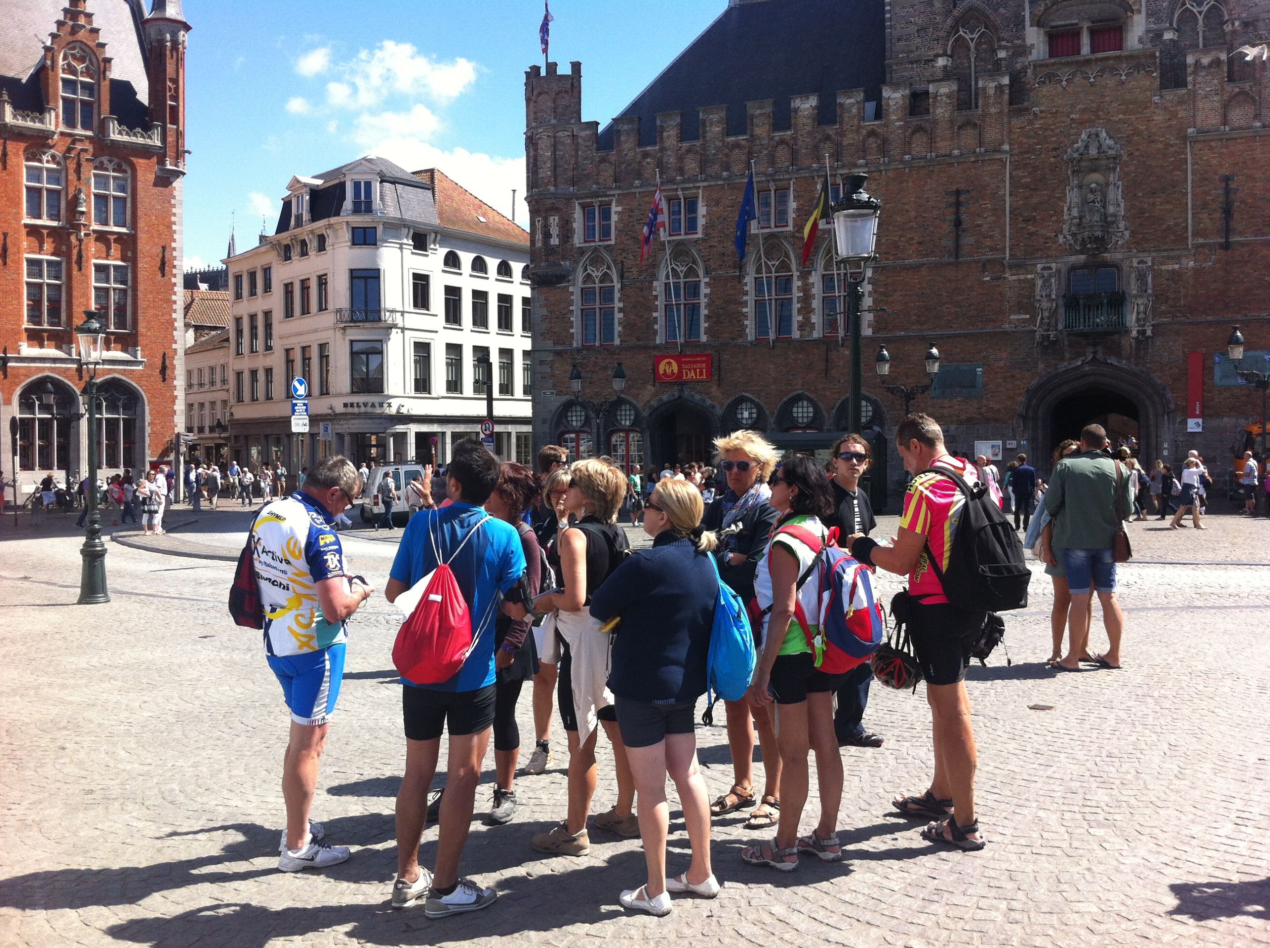 Turisti in piazza centrale a Bruges, con edifici storici e canali, Fiandre in bici e barca